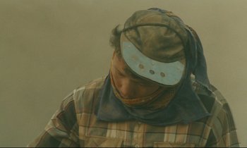 Movie still from “Taste of Cherry” (1997), directed by Abbas Kiarostami – A man wearing a hat and a plaid shirt; Close Up shot, Low angle