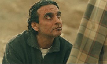 Movie still from “Taste of Cherry” (1997), directed by Abbas Kiarostami – A person looking up at the sky; Close Up shot, Over the shoulder angle