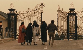 Movie still from “Taste of Cherry” (1997), directed by Abbas Kiarostami – A group of people walking down a street; Wide shot, Low angle