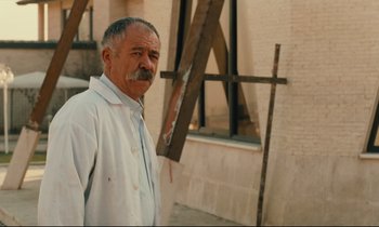 Movie still from “Taste of Cherry” (1997), directed by Abbas Kiarostami – An older man standing in front of an easel; Medium shot, Low angle