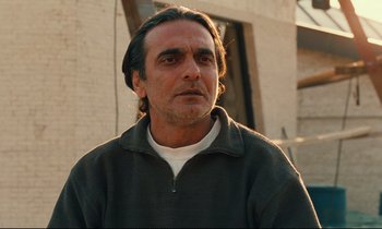 Movie still from “Taste of Cherry” (1997), directed by Abbas Kiarostami – A person wearing a jacket; Close Up shot, Low angle