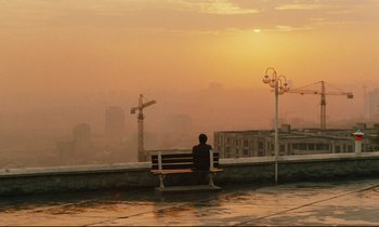 Movie still from “Taste of Cherry” (1997), directed by Abbas Kiarostami – A man sitting on a bench looking out over a city; Extreme Wide shot, Over the shoulder angle