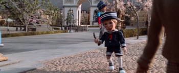 Movie still from “Team America: World Police” (2004), directed by Trey Parker – A boy dressed as a sailor walking down the street; Wide shot, High angle