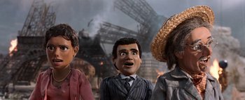 Movie still from “Team America: World Police” (2004), directed by Trey Parker – A group of people standing next to each other in front of an oil rig; Close Up shot, Low angle