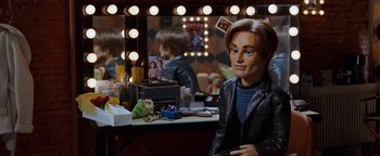 Movie still from “Team America: World Police” (2004), directed by Trey Parker – A man sitting in front of a vanity mirror; Medium shot, High angle