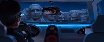 Movie still from “Team America: World Police” (2004), directed by Trey Parker – A view from inside of a car with a reflection of a man in the mirror; Close Up shot, Over the shoulder angle
