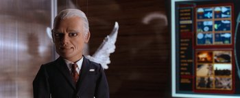 Movie still from “Team America: World Police” (2004), directed by Trey Parker – A man in a suit and tie with a white angel wing; Close Up shot, Low angle