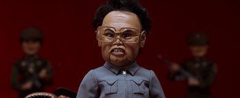 Movie still from “Team America: World Police” (2004), directed by Trey Parker – A doll wearing glasses; Close Up shot, Low angle