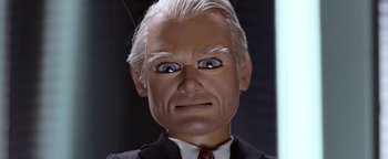 Movie still from “Team America: World Police” (2004), directed by Trey Parker – An old man with white hair wearing a suit and tie; Close Up shot, Low angle