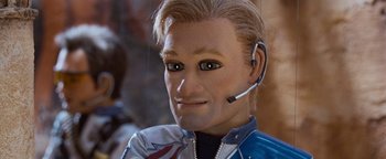 Movie still from “Team America: World Police” (2004), directed by Trey Parker – A person wearing a headset; Close Up shot, Low angle