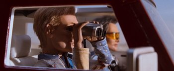 Movie still from “Team America: World Police” (2004), directed by Trey Parker – A woman holding a camera up to her eye; Close Up shot, Low angle