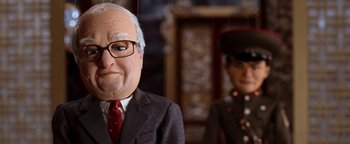 Movie still from “Team America: World Police” (2004), directed by Trey Parker – A man's face and a man's head; Close Up shot, Low angle