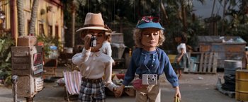 Movie still from “Team America: World Police” (2004), directed by Trey Parker – A couple of people that are holding hands; Medium shot, Low angle