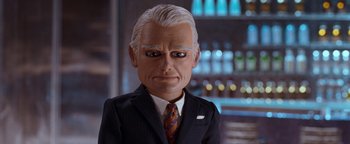 Movie still from “Team America: World Police” (2004), directed by Trey Parker – A man in a business suit and tie; Close Up shot, Low angle