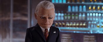 Movie still from “Team America: World Police” (2004), directed by Trey Parker – A man in a suit and tie with a strange look on his face; Close Up shot, Low angle