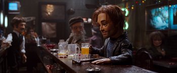Movie still from “Team America: World Police” (2004), directed by Trey Parker – A man sitting at a bar with two glasses of beer in front of him; Close Up shot, Over the shoulder angle