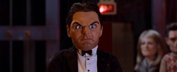 Movie still from “Team America: World Police” (2004), directed by Trey Parker – A man wearing a suit and bow tie; Close Up shot, Low angle