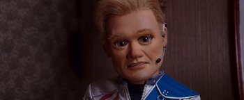 Movie still from “Team America: World Police” (2004), directed by Trey Parker – The face of a man wearing a headset; Close Up shot, Low angle