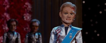 Movie still from “Team America: World Police” (2004), directed by Trey Parker – A doll with a face paint and a bandage around it's neck; Close Up shot, Low angle