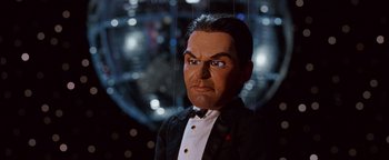 Movie still from “Team America: World Police” (2004), directed by Trey Parker – A wax figure of a man wearing a tuxedo; Close Up shot, Low angle