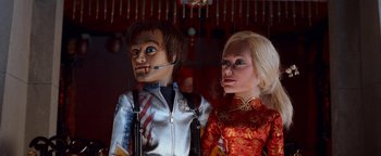 Movie still from “Team America: World Police” (2004), directed by Trey Parker – A man and a woman are standing next to each other; Close Up shot, Low angle