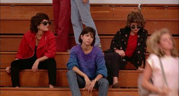 Movie still from “Teen Wolf” (1985), directed by Rod Daniel – A group of women sitting on top of a wooden bleacher; Medium shot, Low angle