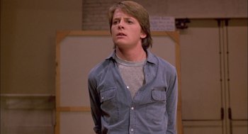 Movie still from “Teen Wolf” (1985), directed by Rod Daniel – A young man in a blue shirt is looking up; Medium shot, Low angle