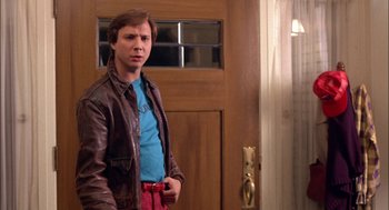 Movie still from “Teen Wolf” (1985), directed by Rod Daniel – A man standing in front of a door wearing a leather jacket; Medium shot, Over the shoulder angle