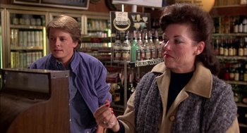 Movie still from “Teen Wolf” (1985), directed by Rod Daniel – A woman and a boy are in a bar; Medium shot, Over the shoulder angle
