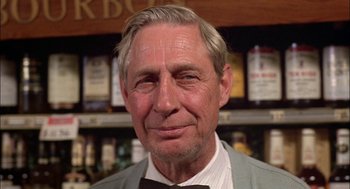 Movie still from “Teen Wolf” (1985), directed by Rod Daniel – An older man wearing a suit and bow tie in a bar; Close Up shot, Low angle