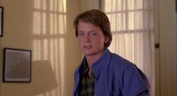 Movie still from “Teen Wolf” (1985), directed by Rod Daniel – A young man in a blue shirt is looking at the camera; Close Up shot, Over the shoulder angle