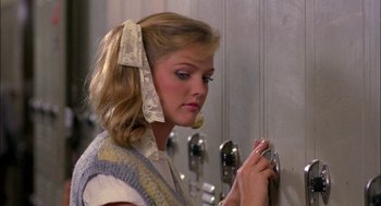 Movie still from “Teen Wolf” (1985), directed by Rod Daniel – A young woman is looking at her cell phone; Close Up shot, Over the shoulder angle