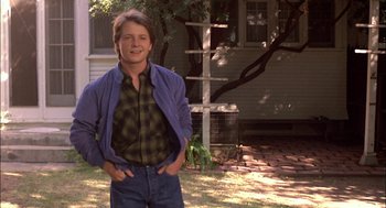 Movie still from “Teen Wolf” (1985), directed by Rod Daniel – A man standing in front of a house in a yard; Medium shot, Low angle