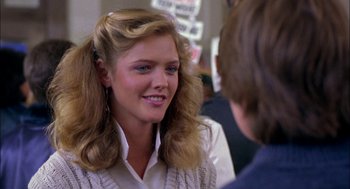 Movie still from “Teen Wolf” (1985), directed by Rod Daniel – A young woman talking to a young man in front of a crowd; Close Up shot, Over the shoulder angle