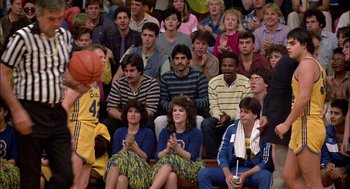Movie still from “Teen Wolf” (1985), directed by Rod Daniel – A group of people watching a basketball game in front of an audience; Wide shot, High angle