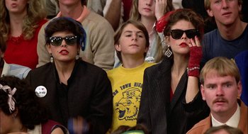 Movie still from “Teen Wolf” (1985), directed by Rod Daniel – A group of people sitting next to each other in a crowd; Close Up shot, Low angle