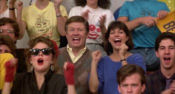 Movie still from “Teen Wolf” (1985), directed by Rod Daniel – A group of people sitting and standing in front of each other; Close Up shot, Over the shoulder angle