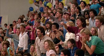 Movie still from “Teen Wolf” (1985), directed by Rod Daniel – A group of people in the bleachers at a sporting event; Wide shot, High angle