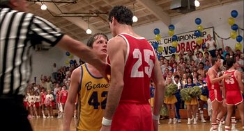 Movie still from “Teen Wolf” (1985), directed by Rod Daniel – A couple of men standing on top of a basketball court; Medium shot, Over the shoulder angle