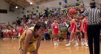 Movie still from “Teen Wolf” (1985), directed by Rod Daniel – A group of young men playing a game of basketball in front of a crowd; Wide shot, Over the shoulder angle