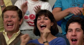 Movie still from “Teen Wolf” (1985), directed by Rod Daniel – A group of people that are sitting in a room together; Close Up shot, Low angle