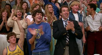 Movie still from “Teen Wolf” (1985), directed by Rod Daniel – A group of people standing in a room clapping; Medium shot, Low angle
