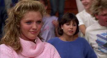 Movie still from “Teen Wolf” (1985), directed by Rod Daniel – A woman in a pink sweater and a group of other people; Close Up shot, Over the shoulder angle