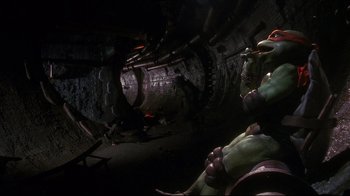 Movie still from “Teenage Mutant Ninja Turtles” (1990), directed by Steve Barron – A group of people standing in an underground tunnel; Wide shot, Low angle