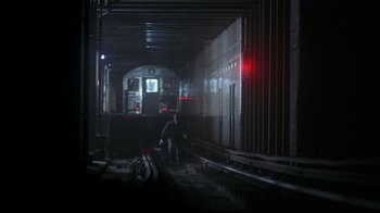 Movie still from “Teenage Mutant Ninja Turtles” (1990), directed by Steve Barron – A man walking on a train track in a tunnel; Extreme Wide shot, High angle