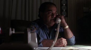 Movie still from “Teenage Mutant Ninja Turtles” (1990), directed by Steve Barron – A man sitting at a table talking on a phone; Close Up shot, Low angle