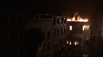 Movie still from “Teenage Mutant Ninja Turtles” (1990), directed by Steve Barron – A building that is on fire at night time; Extreme Wide shot, High angle