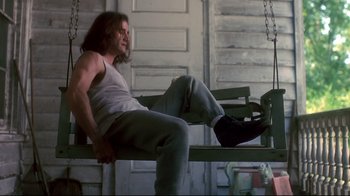 Movie still from “Teenage Mutant Ninja Turtles” (1990), directed by Steve Barron – A man sitting on top of a bench; Medium shot, Low angle