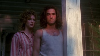 Movie still from “Teenage Mutant Ninja Turtles” (1990), directed by Steve Barron – A man and a woman standing next to each other in front of a door; Medium shot, Low angle