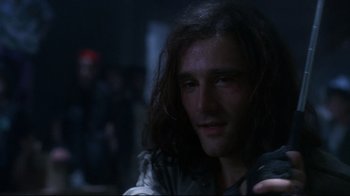 Movie still from “Teenage Mutant Ninja Turtles” (1990), directed by Steve Barron – A person with long dark hair; Close Up shot, Over the shoulder angle